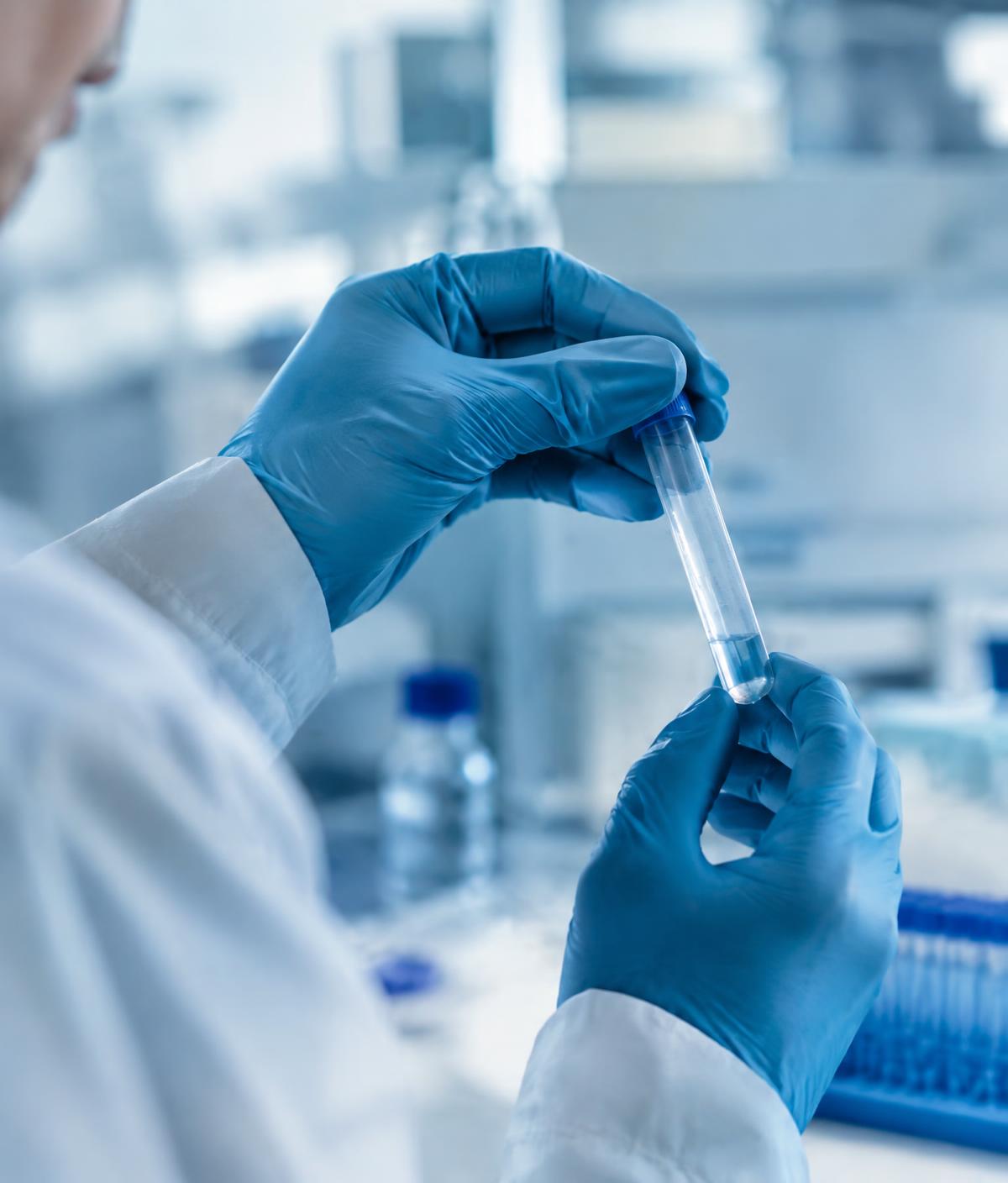 Scientist examining a sample tube